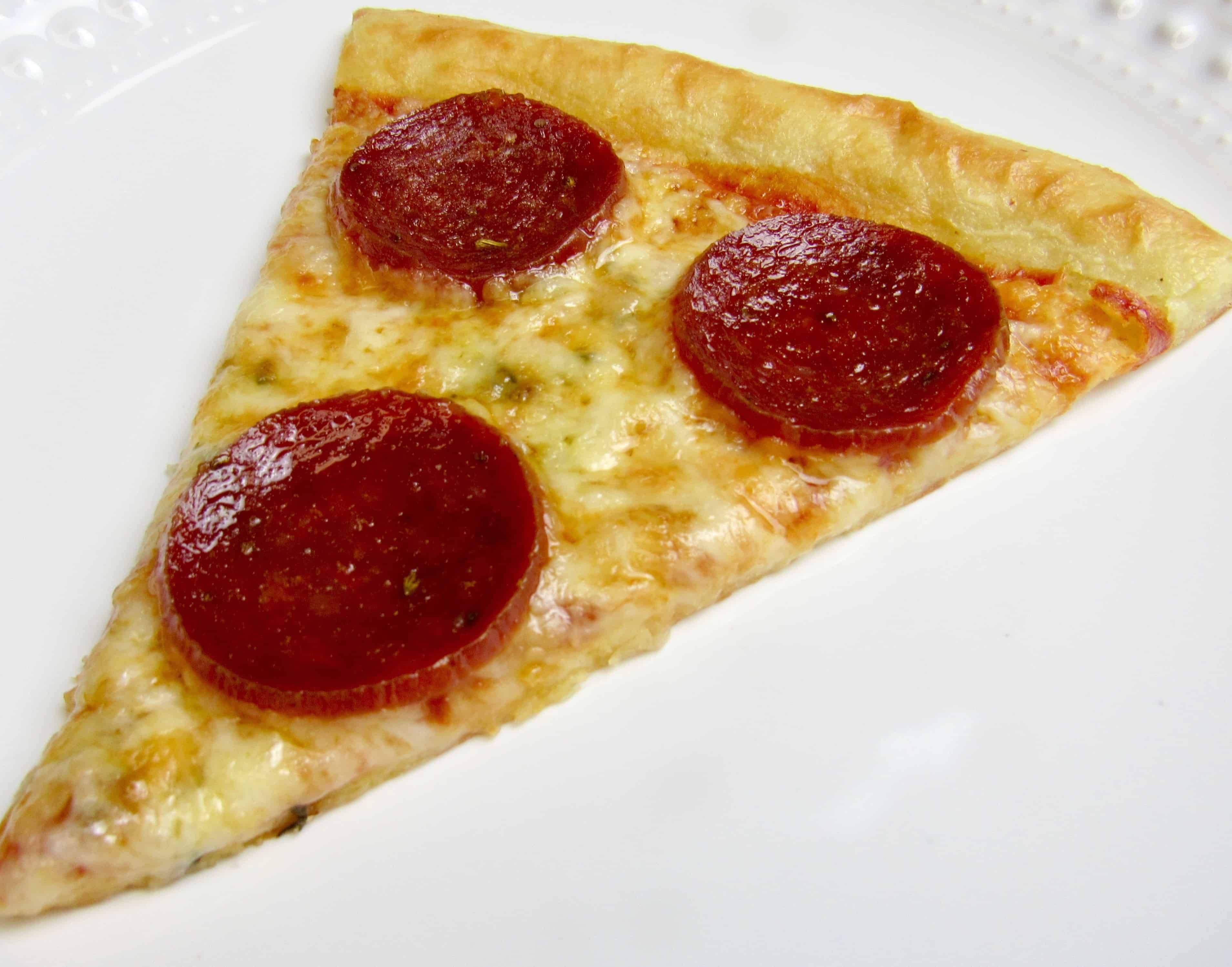 slice of pepperoni pizza on white plate