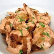 bang bang shrimp in bowl with sauce on top