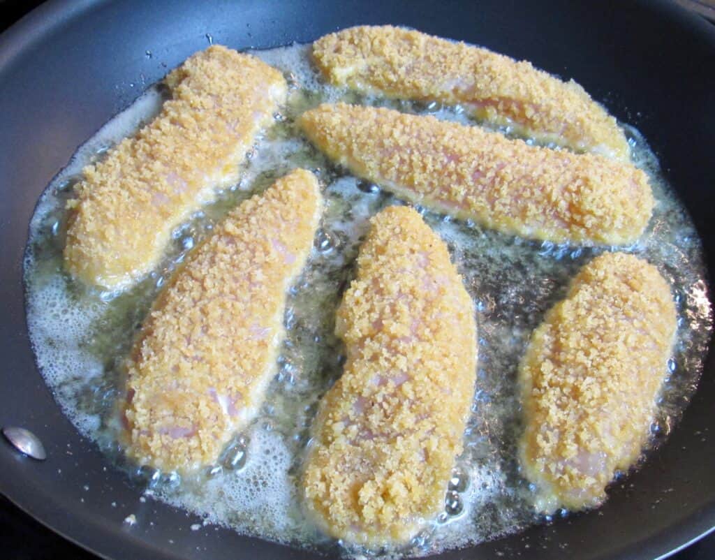chicken tenders frying in skillet