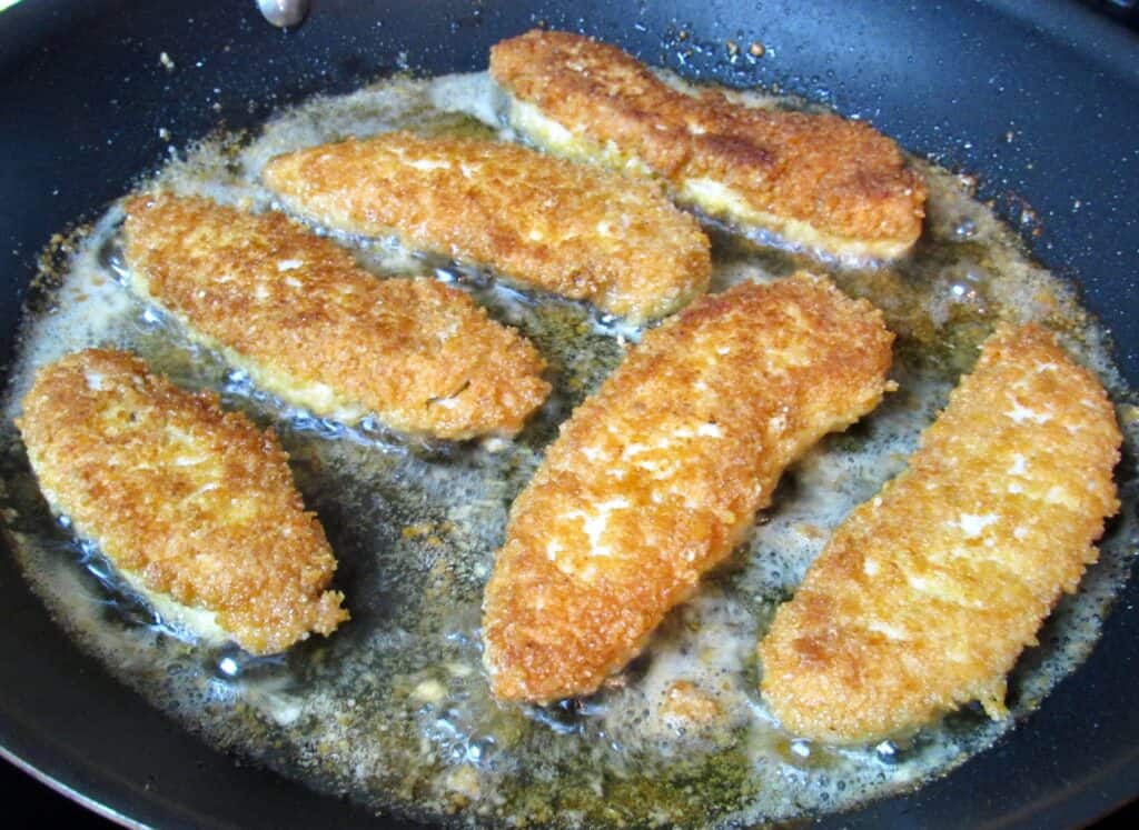 chicken tenders being fried in skillet