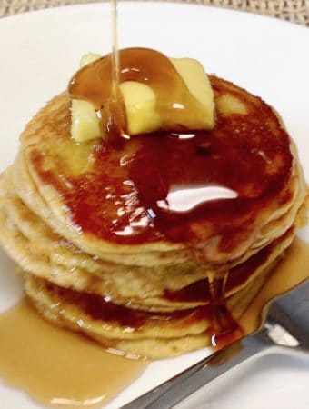 pumpkin pancakes on a plate with butter and syrup