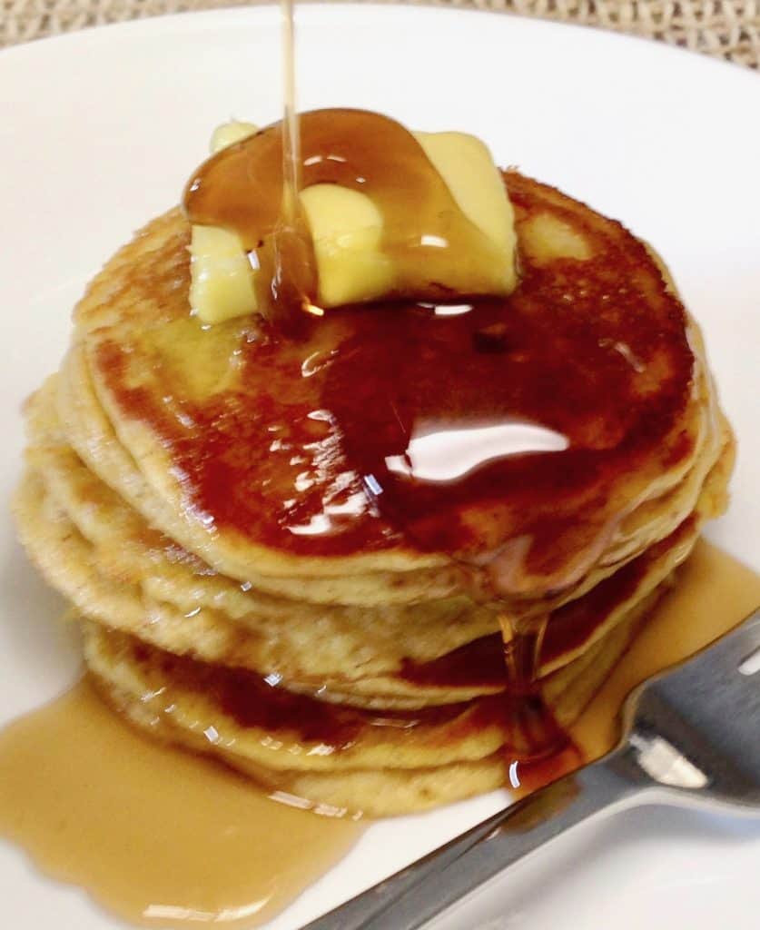 pumpkin pancakes on a plate with butter and syrup