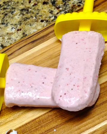 strawberry coconut popsicles on cutting board