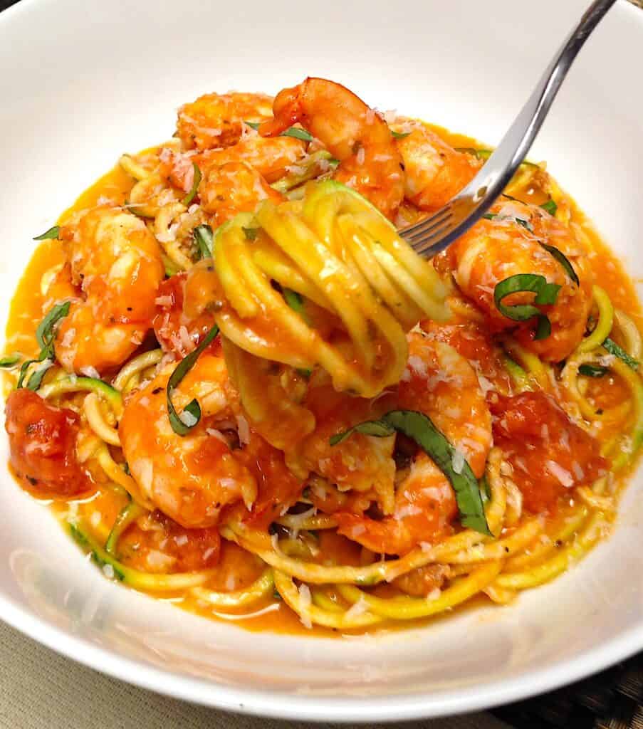 shrimp alla vodka in white bowl with zucchini noodles wrapped around for