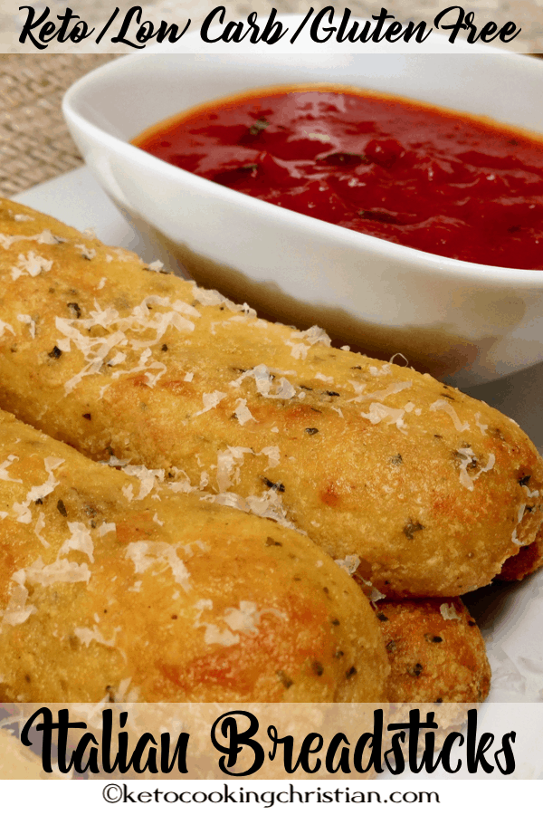 breadsticks on a plate with marinara sauce on the side