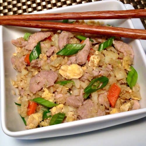 Keto Pork Fried Cauliflower Rice in white bowl with chopsticks