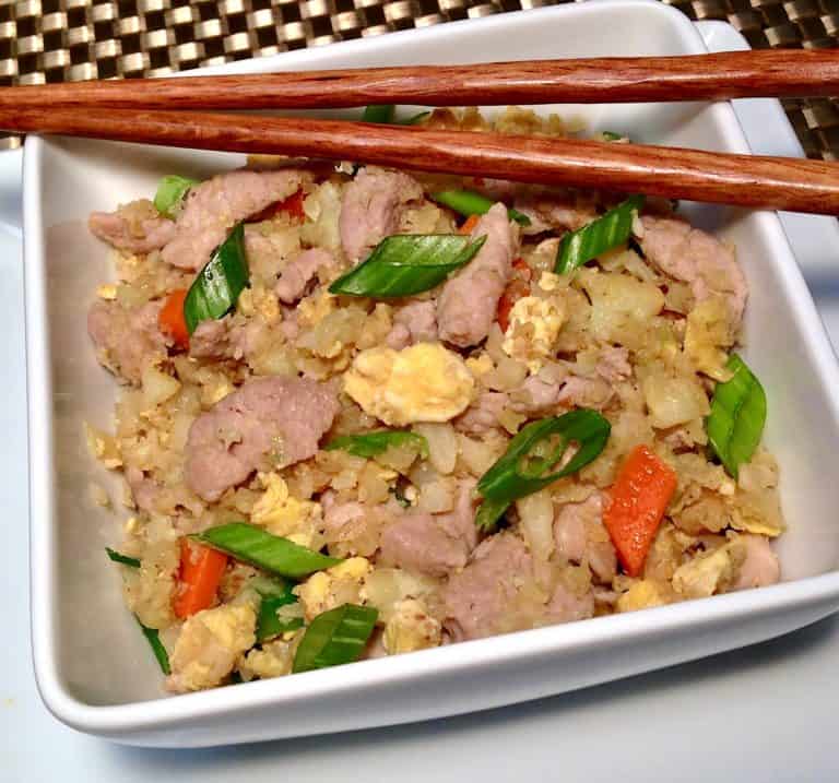 Keto Pork Fried Cauliflower Rice in white bowl with chopsticks