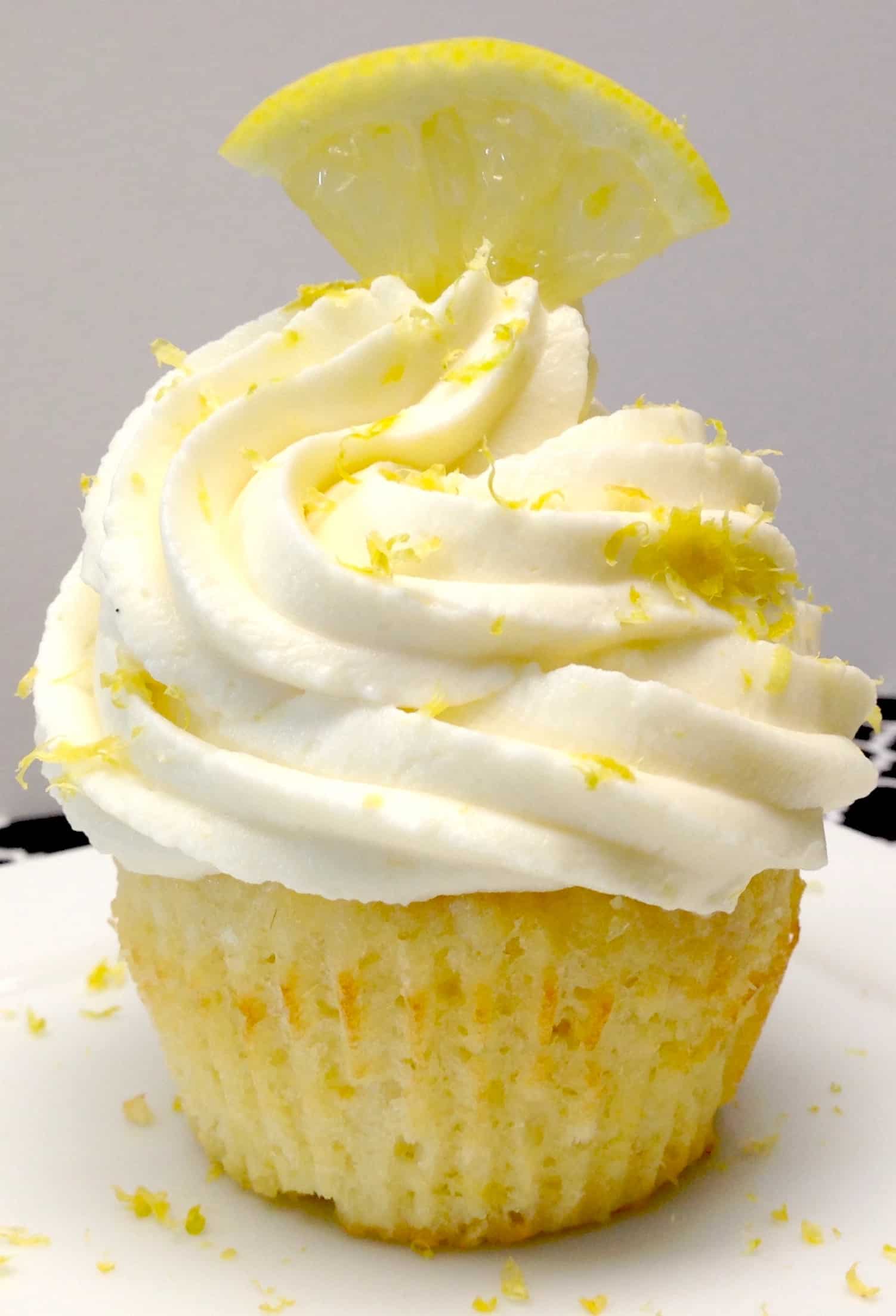 closeup of lemon cupcake with frosting and zest on top