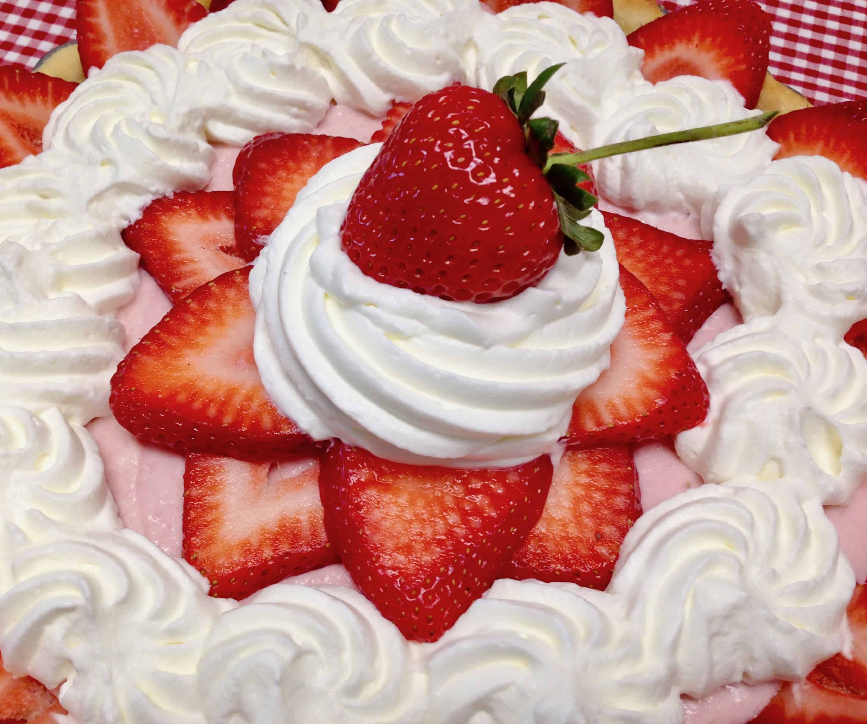 top of strawberry tart with whip cream piped over fresh strawberries