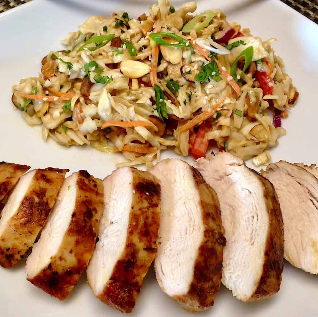 asian grilled chicken sliced on white plate with ginger slaw