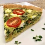 spinach quiche with tomatoes on plate