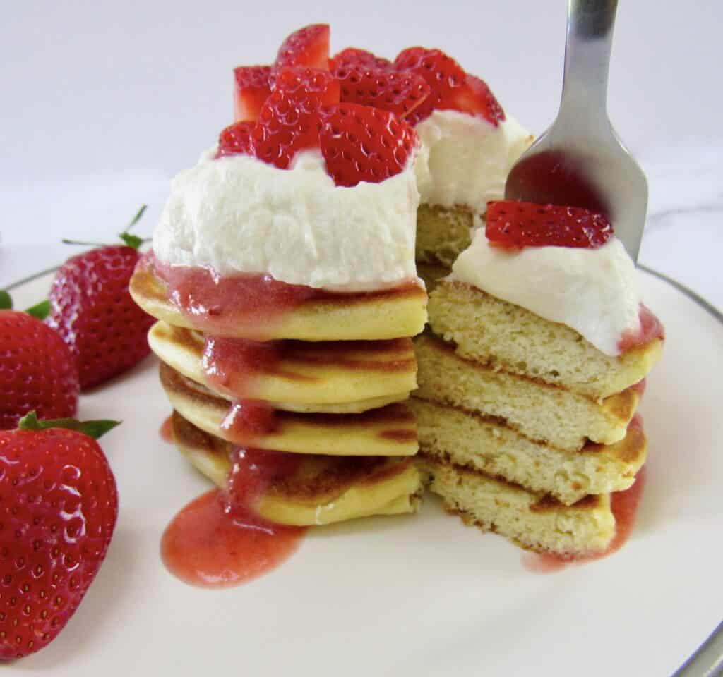 stack of pancakes cut with fork holding some