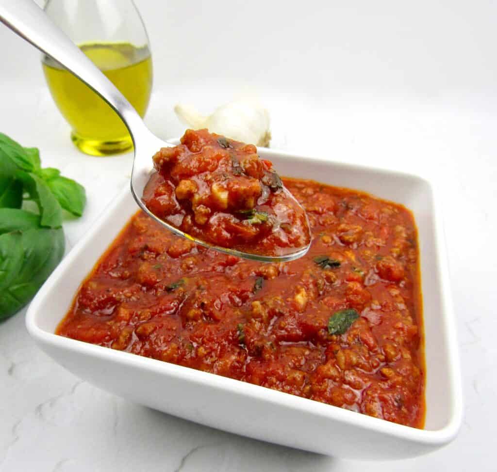 bowl with Italian meat sauce with spoon holding up some