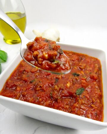 bowl with Italian meat sauce with spoon holding up some