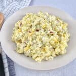 Cauliflower "Potato" Salad in bowl with wooden spoon on the side