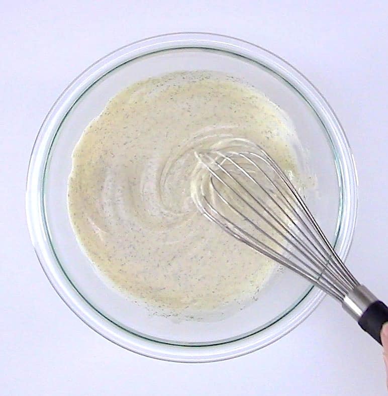 Cauliflower "Potato" Salad dressing in bowl with whisk