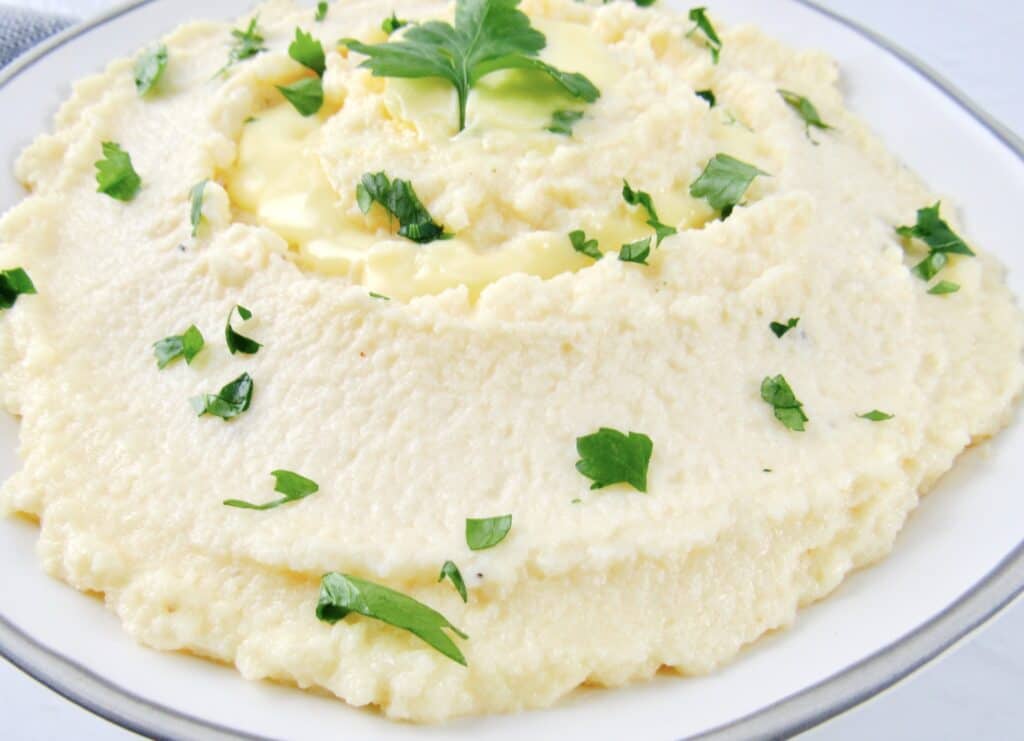 closeup of mashed cauliflower in bowl with parsley