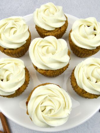 closeup of 6 pumpkin cupcakes with vanilla frosting