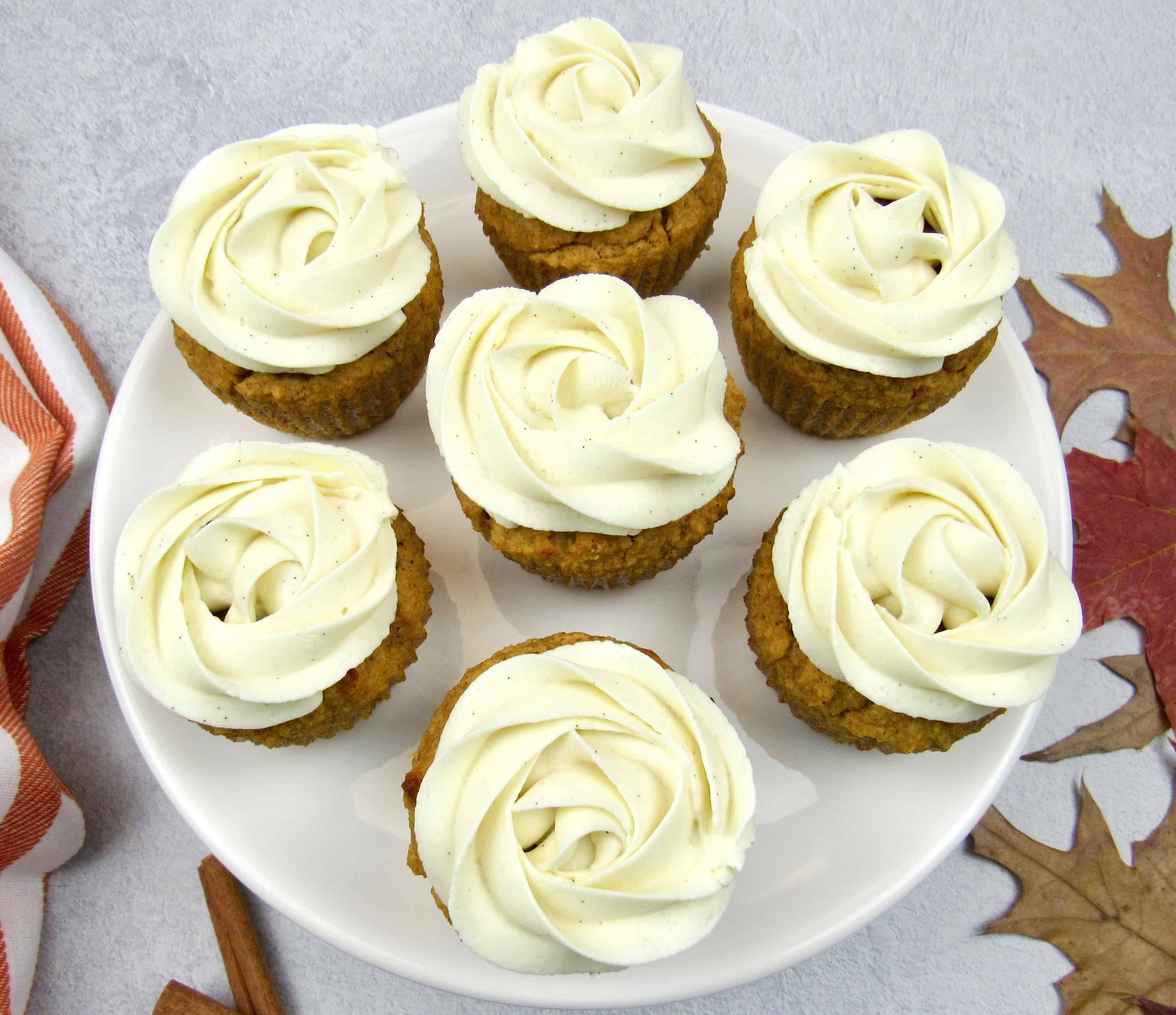 closeup of 6 pumpkin cupcakes with vanilla frosting