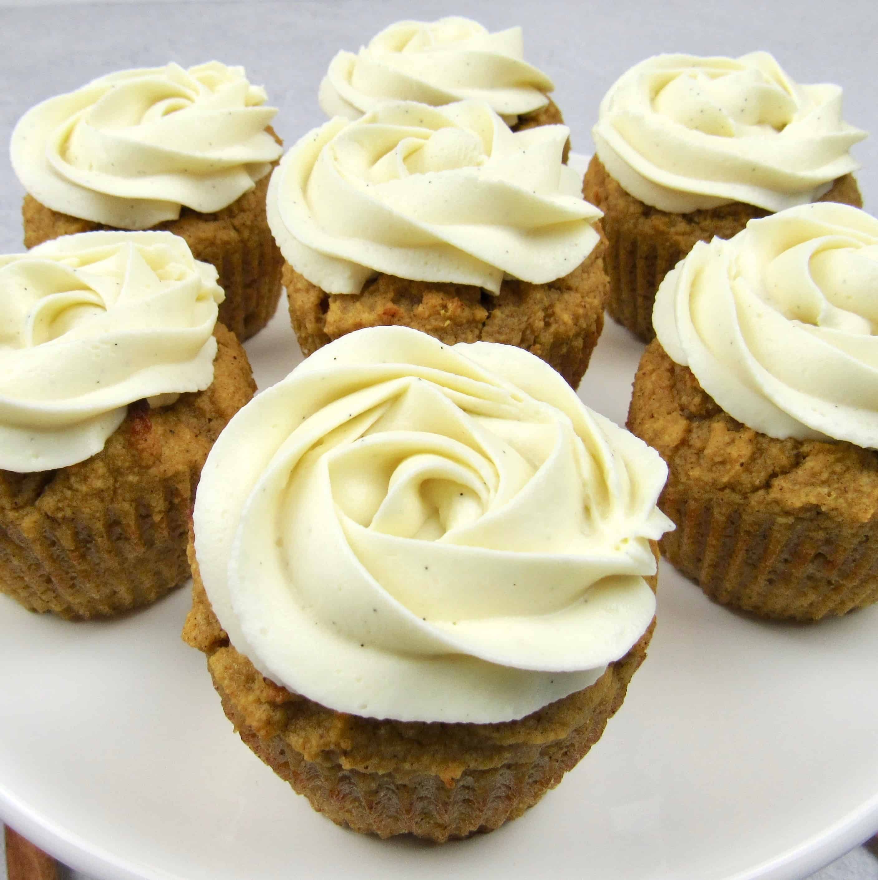 closeup of 6 pumpkin cupcakes with vanilla frosting