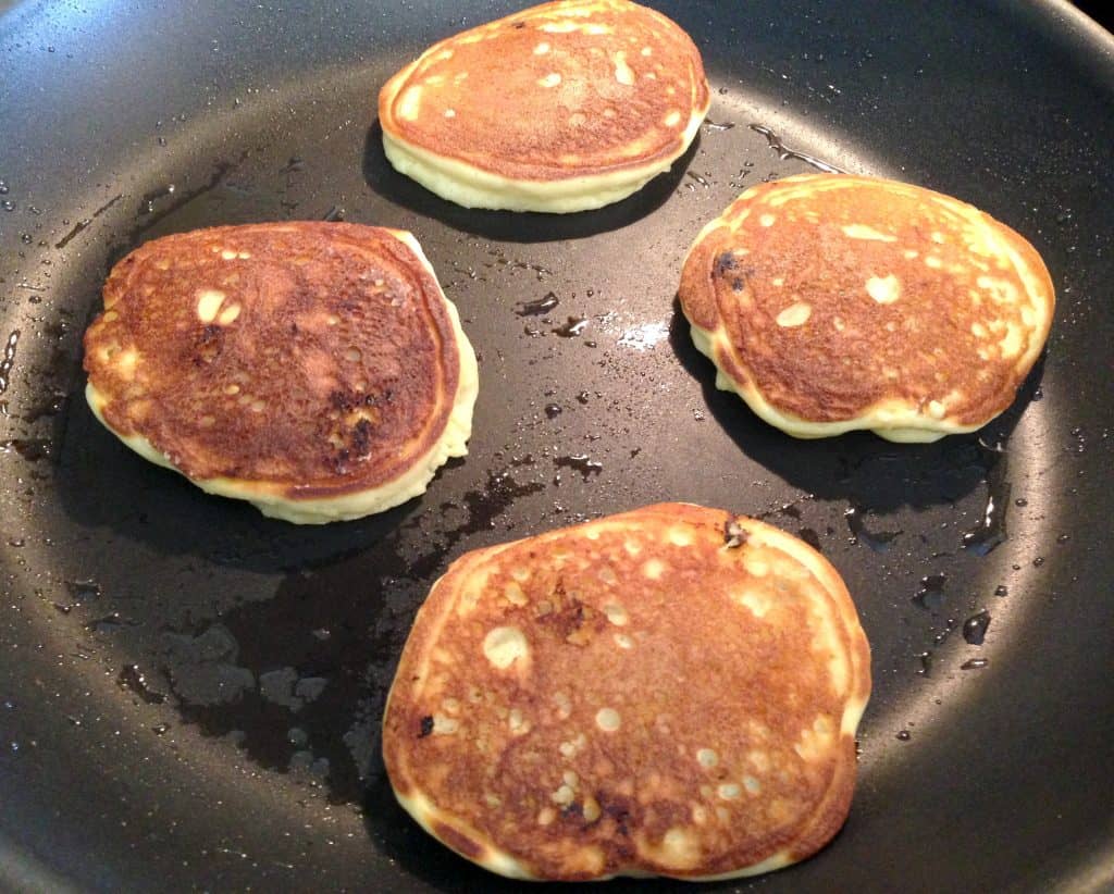 blueberry pancakes cooking in skillet