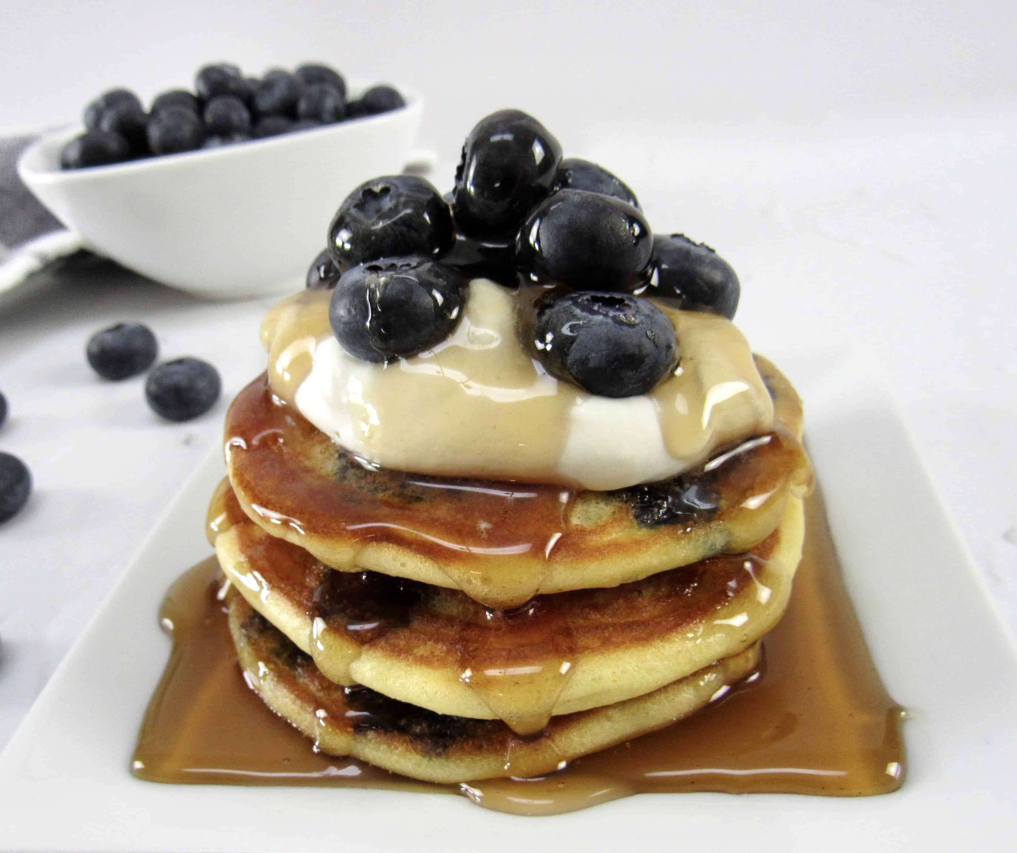 blueberry pancakes with syrup and blueberries on top