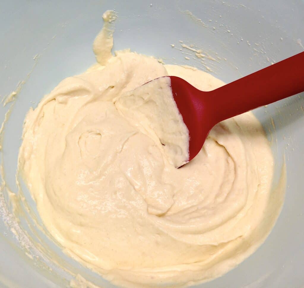 pancakes batter in blue bowl with red spoon