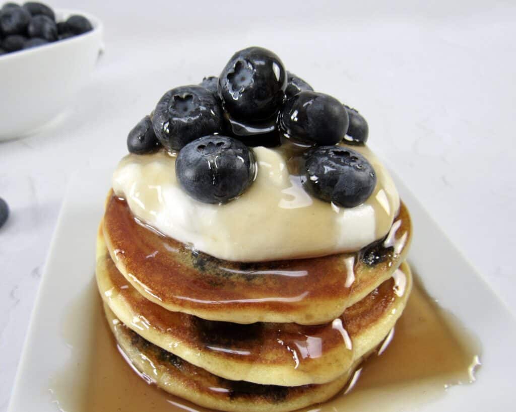 blueberry pancakes with syrup and blueberries on top