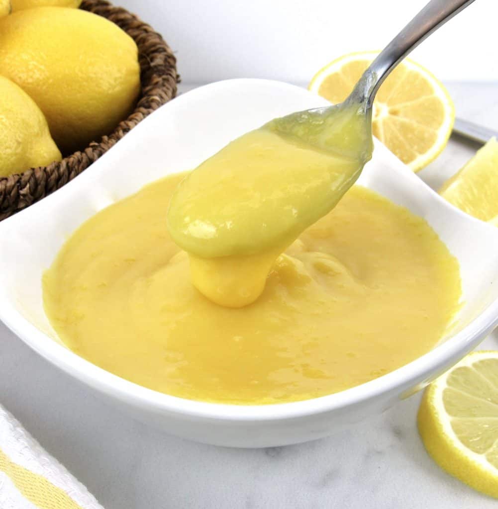 keto lemon curd in white bowl being spooned out