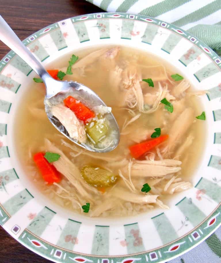 Chicken Soup with cauliflower rice with spoon holding up some out of bowl