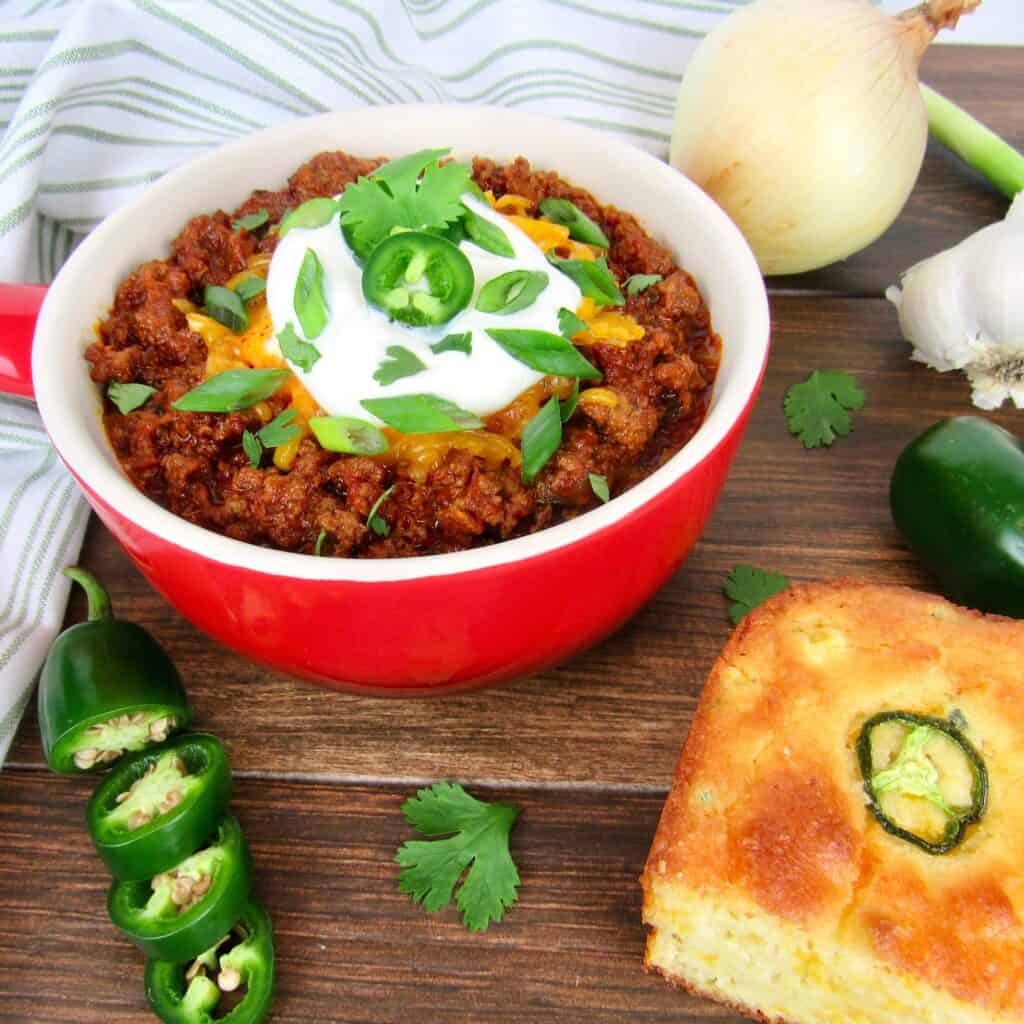 chili in red crock with cornbread slice on the side