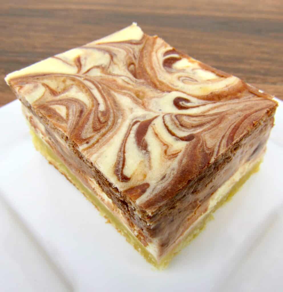 slice of vanilla and chocolate swirl cheesecake on white plate