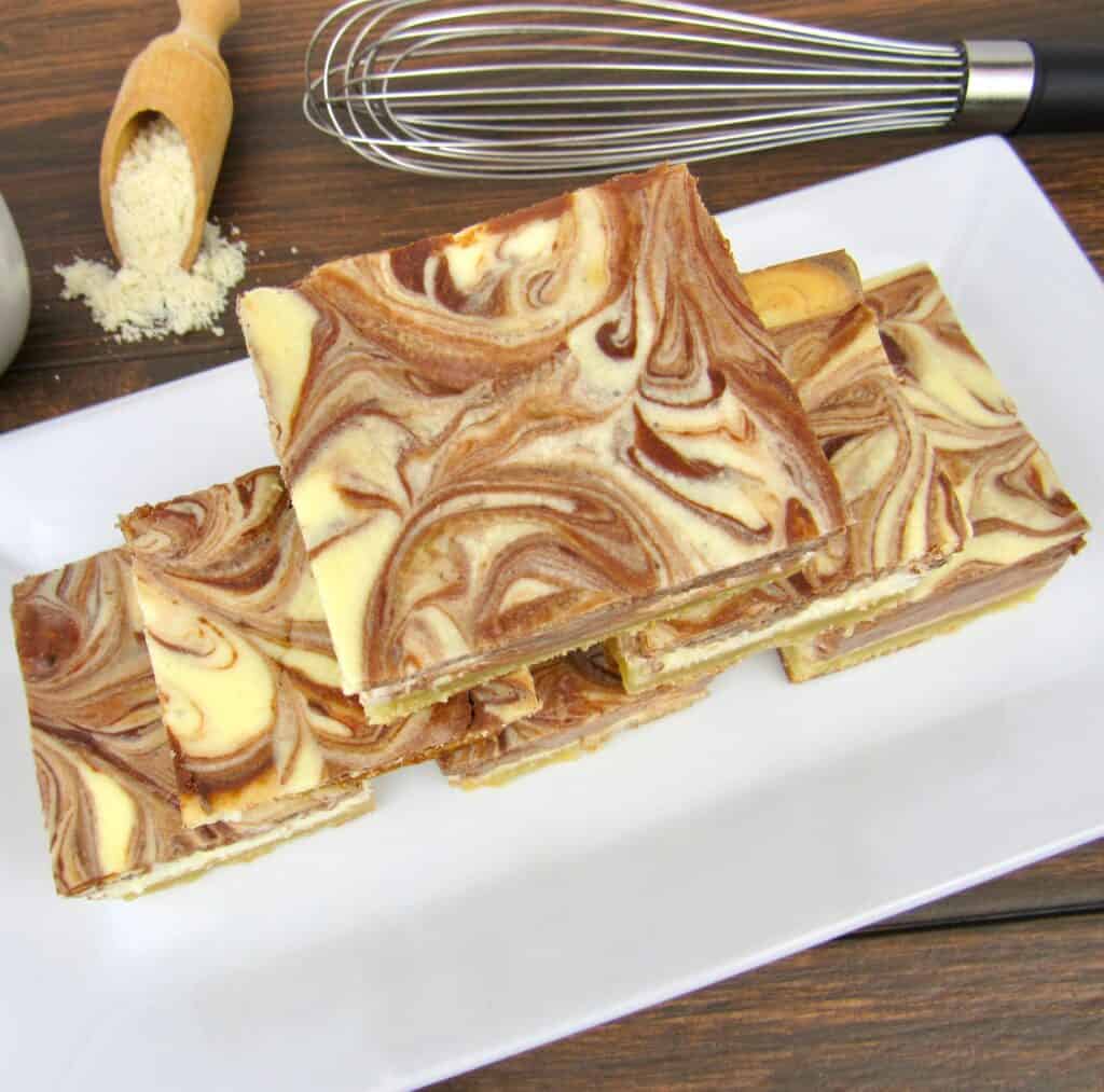 vanilla and chocolate swirl cheesecake slices stacked up on white plate