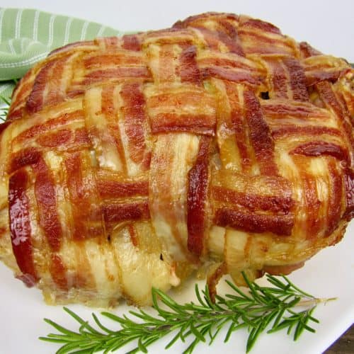bacon wrapped whole chicken on white plate