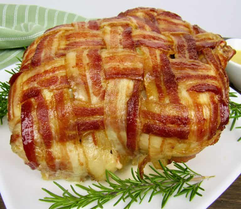bacon wrapped whole chicken on white plate