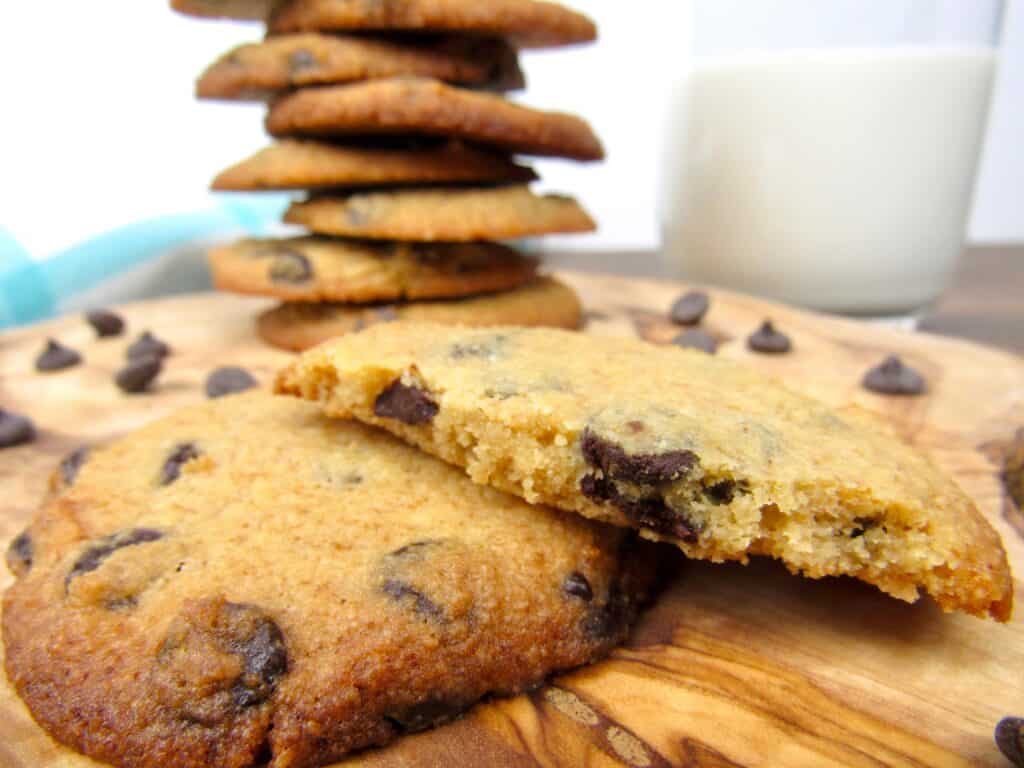 closeup of broken chocolate chip cookies with stack in background