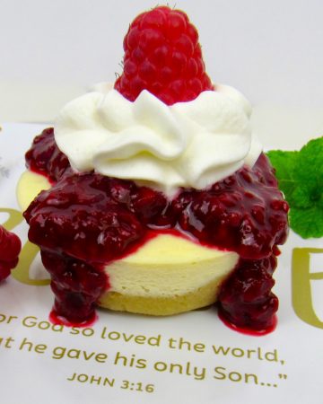 cheesecake with raspberry sauce and whip cream on top