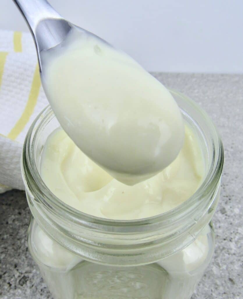 jar of mayonnaise with spoon holding up some