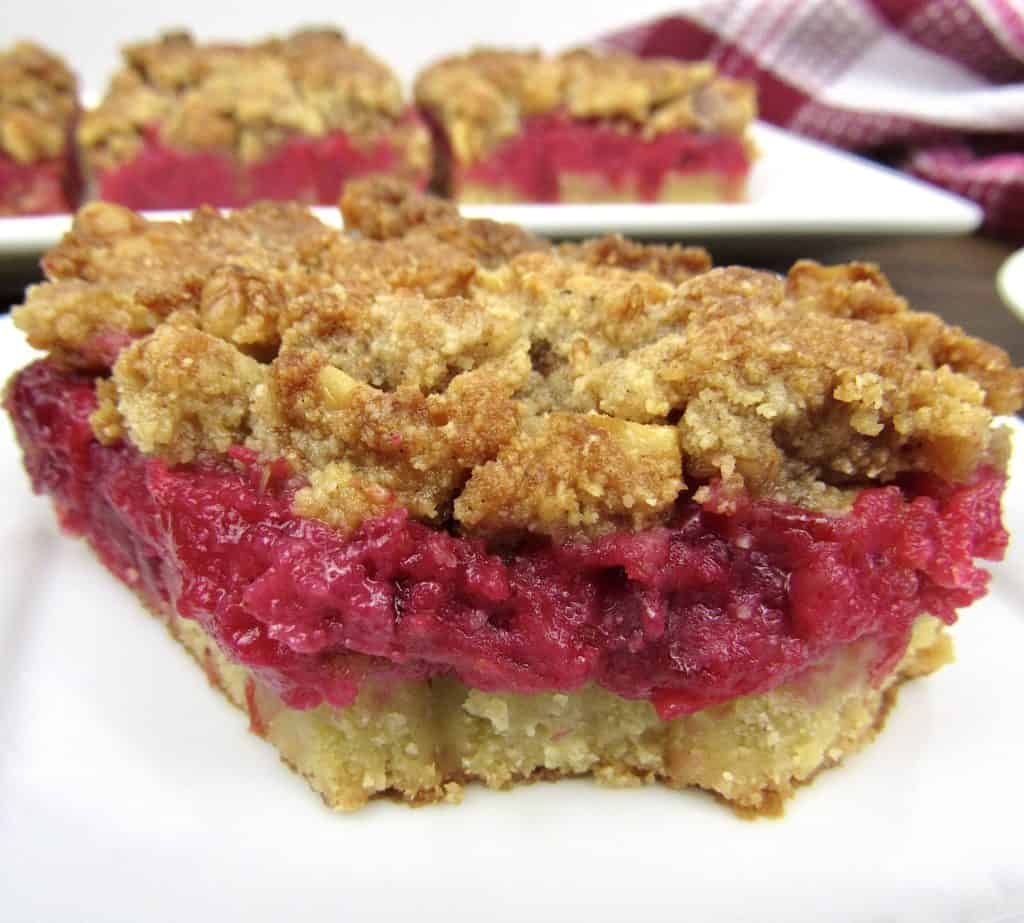 closeup of cranberry walnut crumble bar on white plate