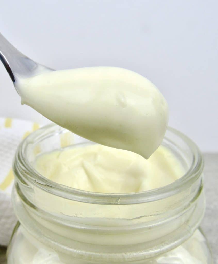 mayonnaise being spooned out of glass jar