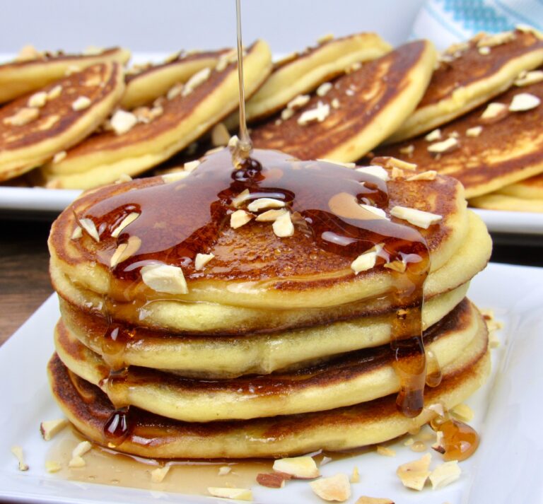 stack of pancakes with syrup being poured over the top