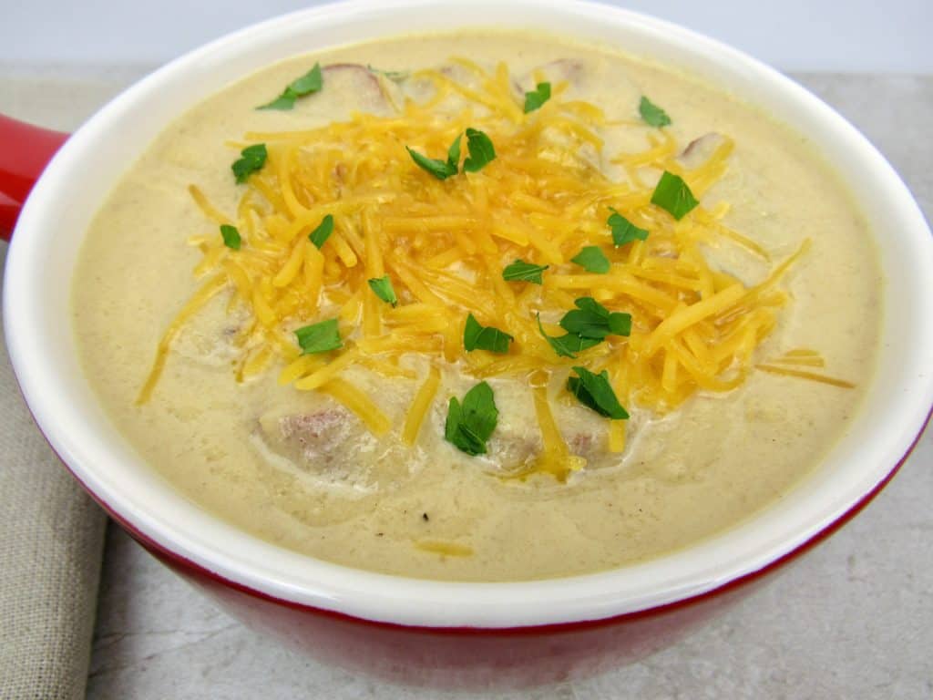 closeup of Smoked Sausage and Cauliflower Soup in red crock