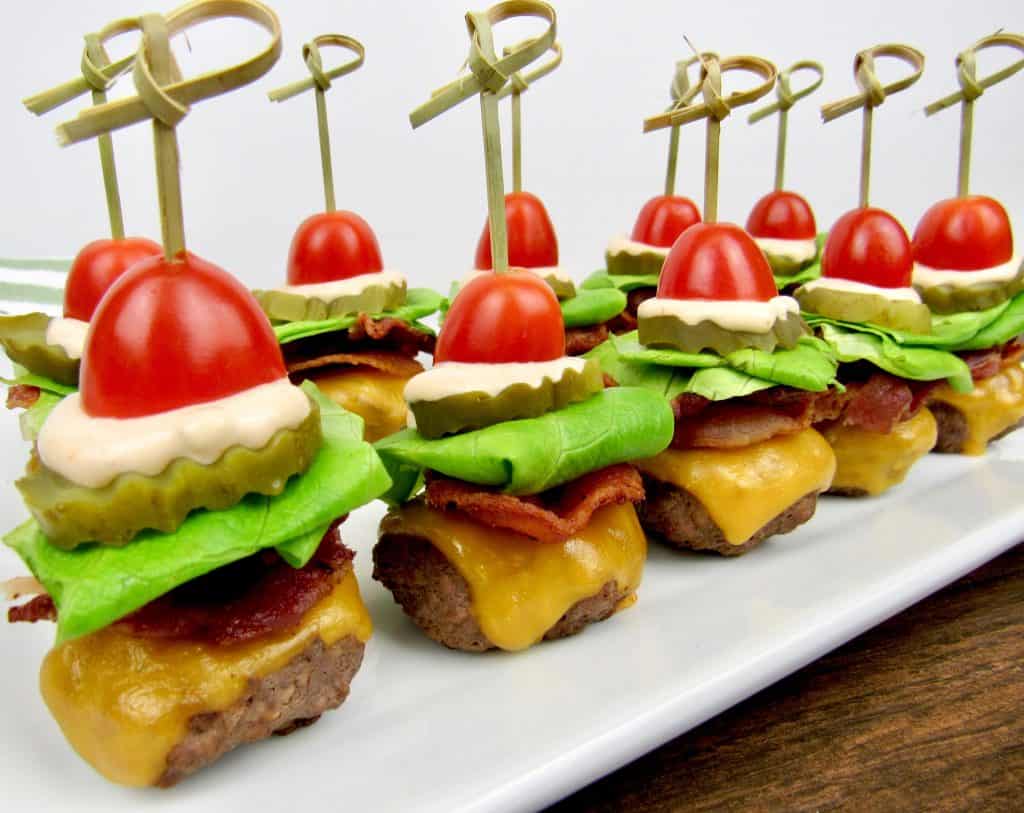 mini burgers with bacon cheese lettuce tomato and thousand island dressing with a skewer through the center