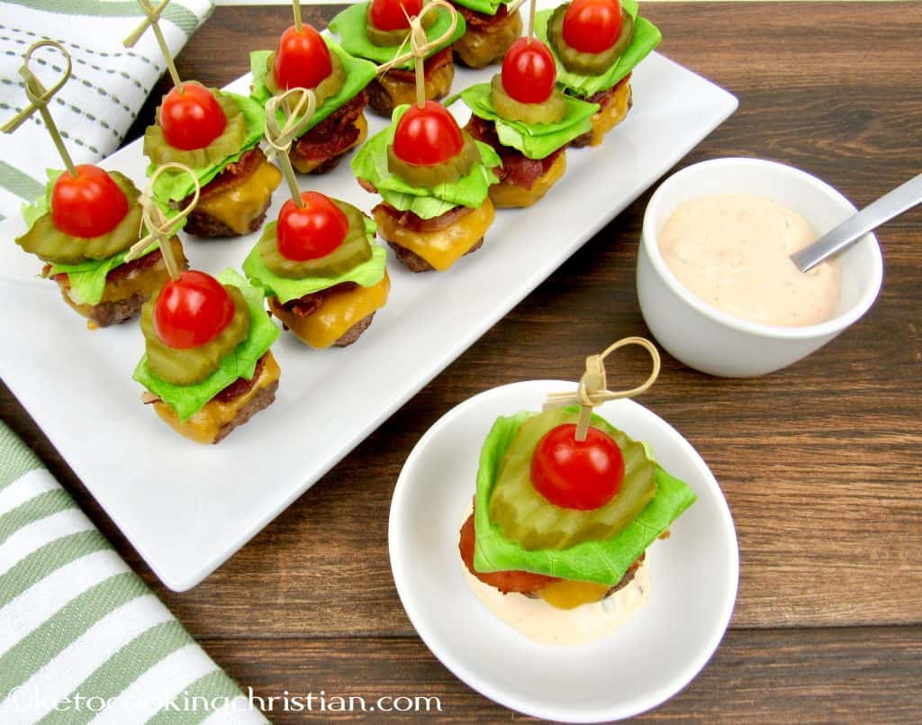 mini burgers with bacon cheese lettuce tomato and thousand island dressing with a skewer through the center