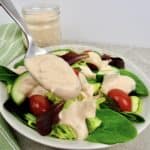thousand island dressing being spooned over salad