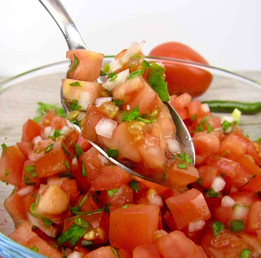 Pico De Gallo in bowl being held up in spoon