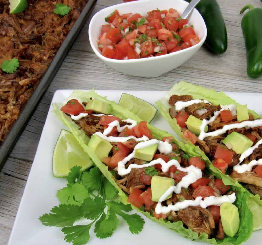 pork carnitas in lettuce wraps with salsa in background