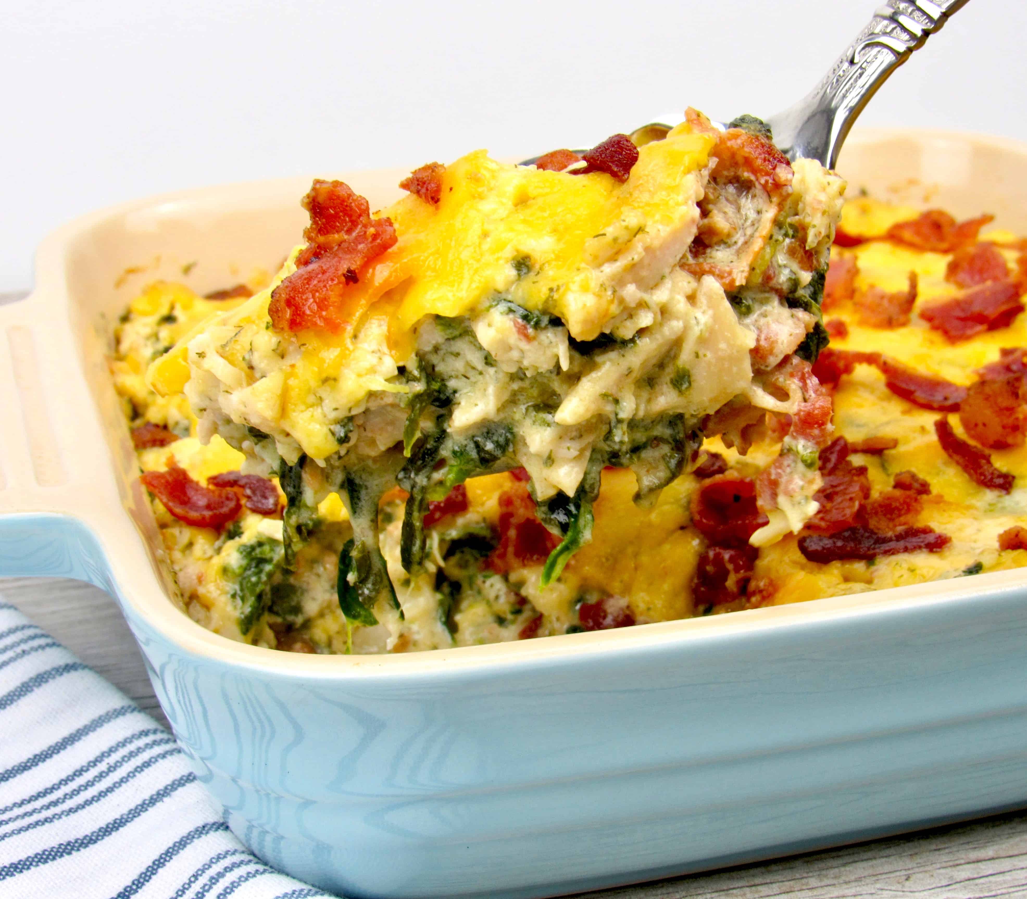 ladle spooning out chicken ranch casserole with cheese and bacon on top