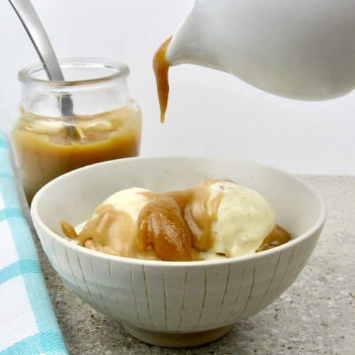 caramel being poured over vanilla ice cream