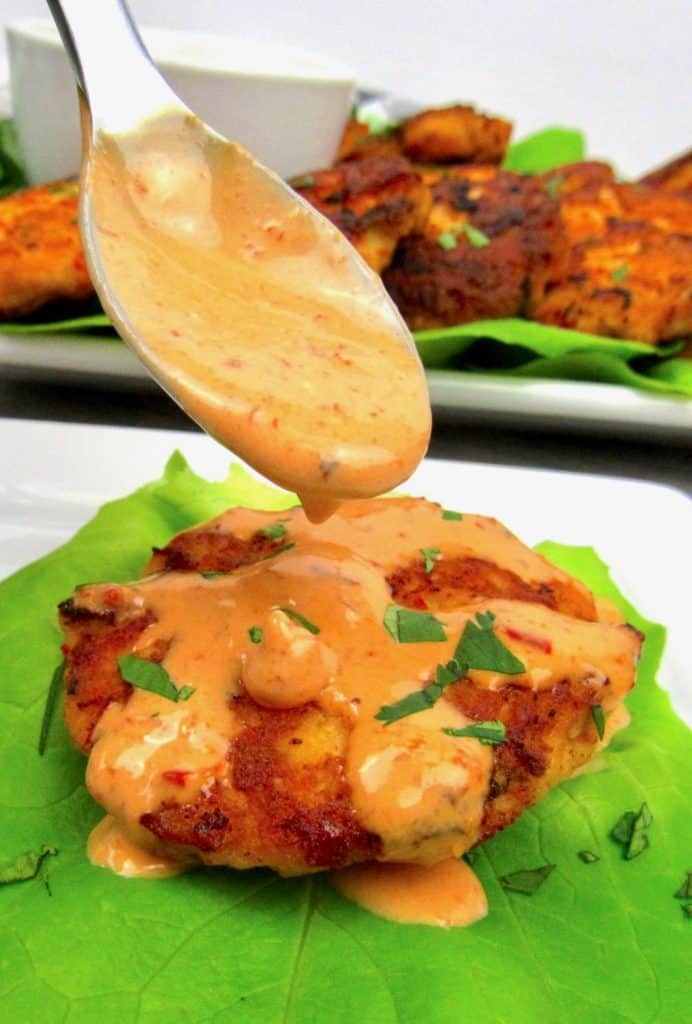Bang Bang Salmon Cakes with sauce being spoon on top